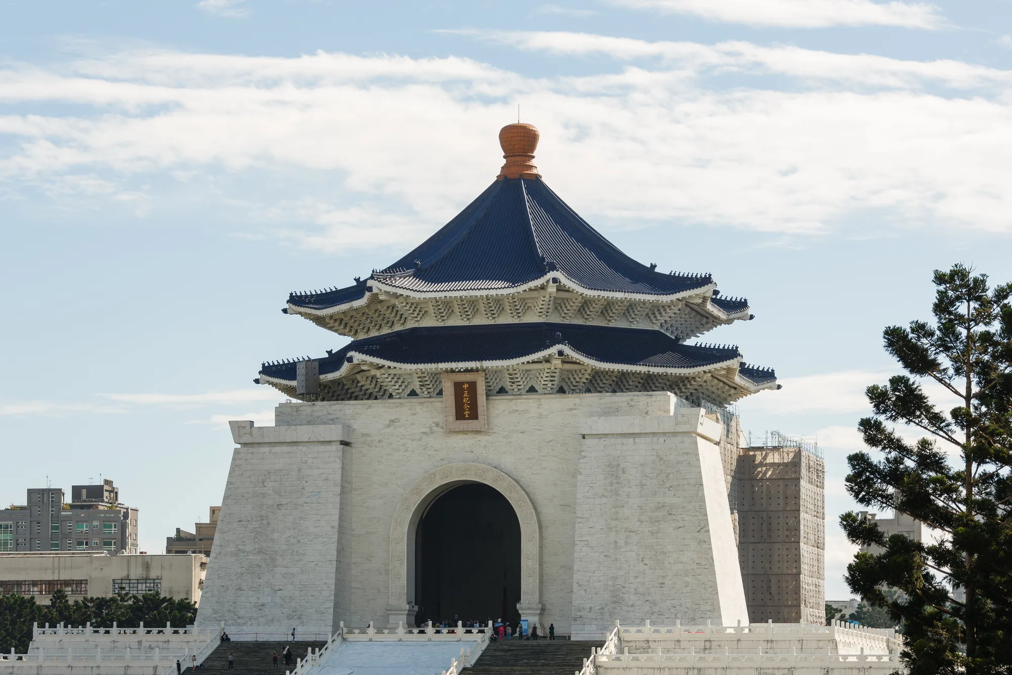 The white Chiang Kai-shek Memorial Hall in Taipei with its blue octagonal roof, ROC flags lining the plaza