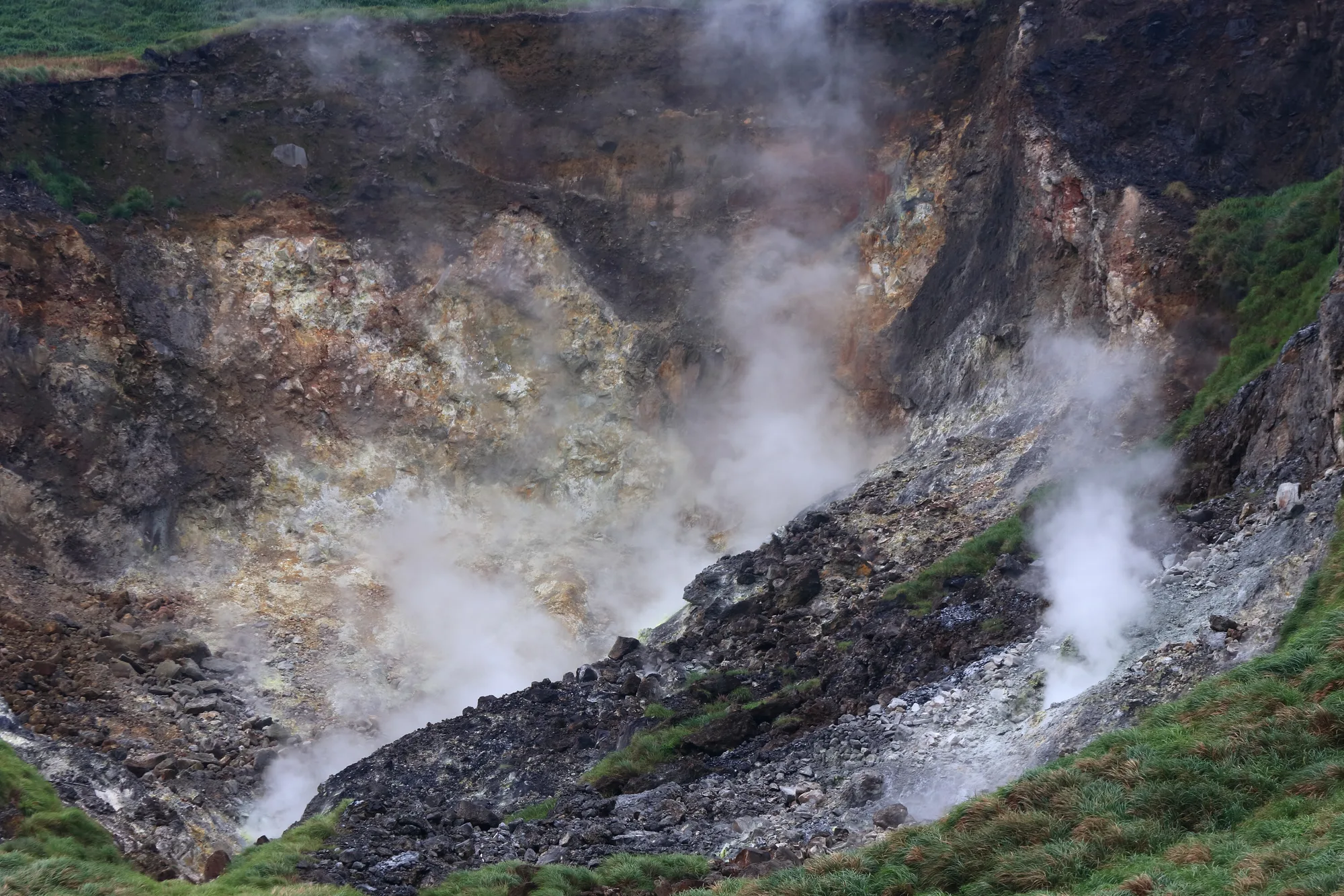 Steam billowing from the sulfur-stained volcanic Xiaoyoukeng fumaroles in Yangmingshan National Park, Taiwan